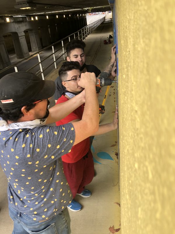 Residents painting panels for Connected in Chaos, collaborative public art in London, Ontario